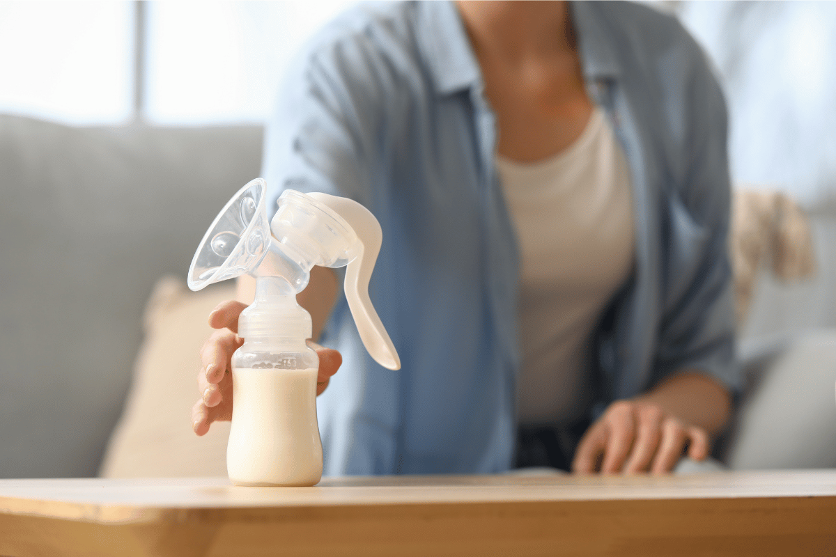 Woman Taking Breast Pump from Table at Home, Closeup