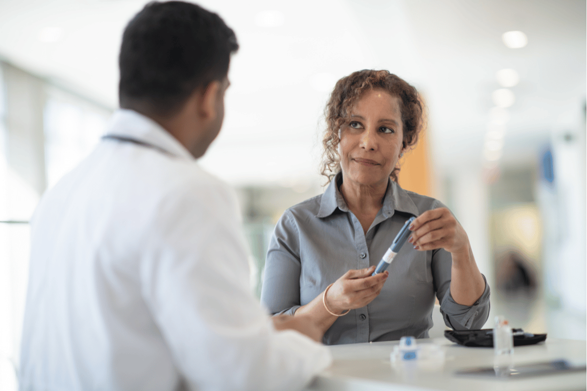 A woman discusses with her doctorabout possibilities for diabetestreatment in a well lit medical facility.